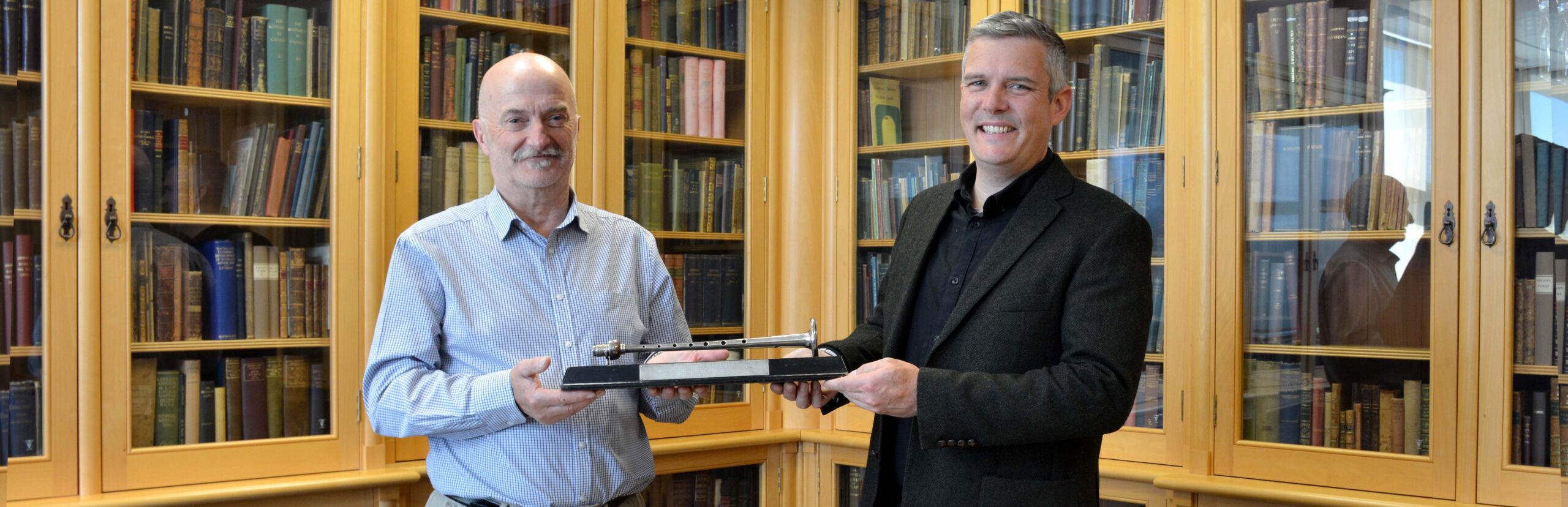 Rob Wallace Pìobaireachd Society hands Silver Chanter over to Dr Decker Forrest in Sabhal Mòr Ostaig library
